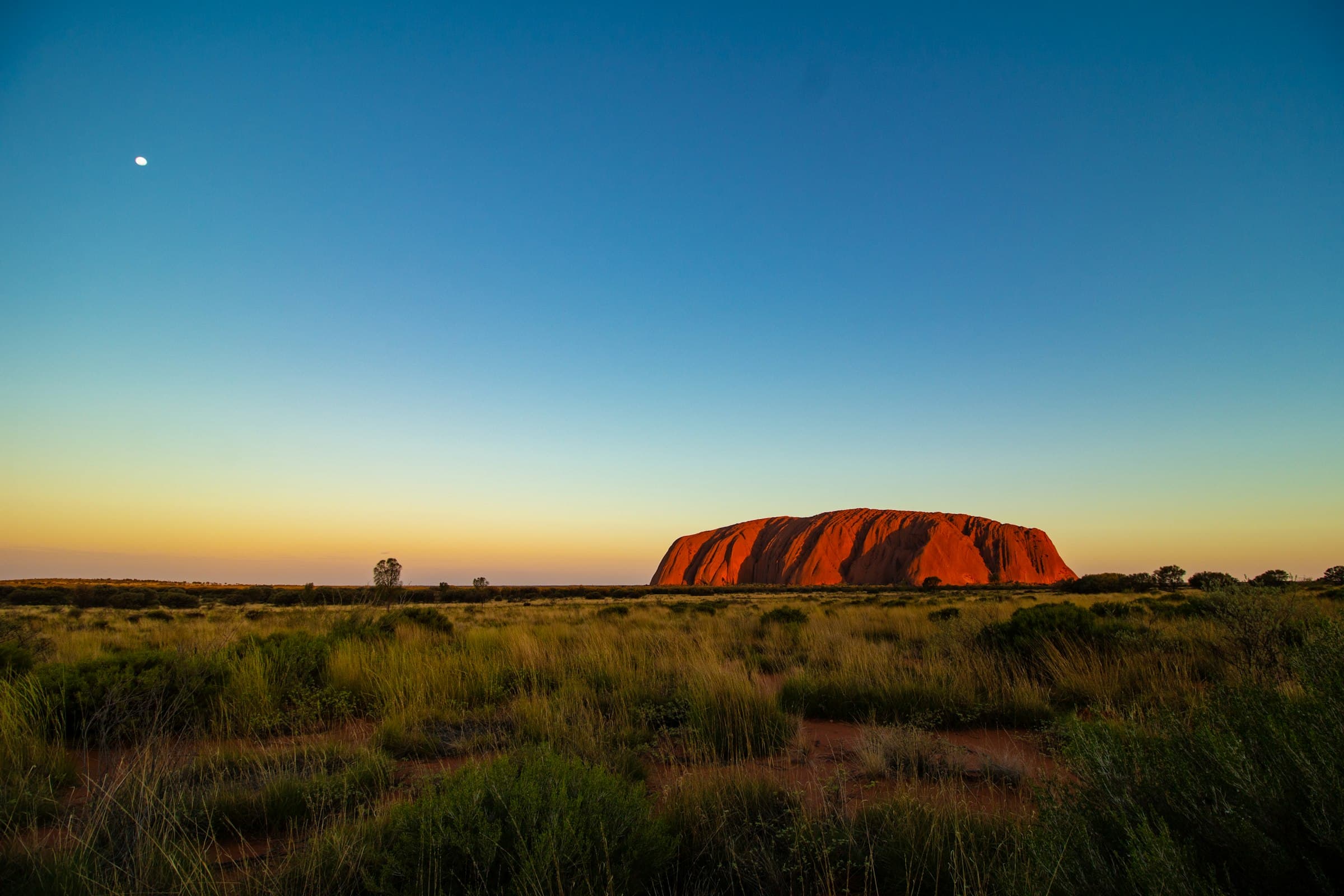 Le monolithe d'Uluru au soleil couchant, au cœur du désert australien