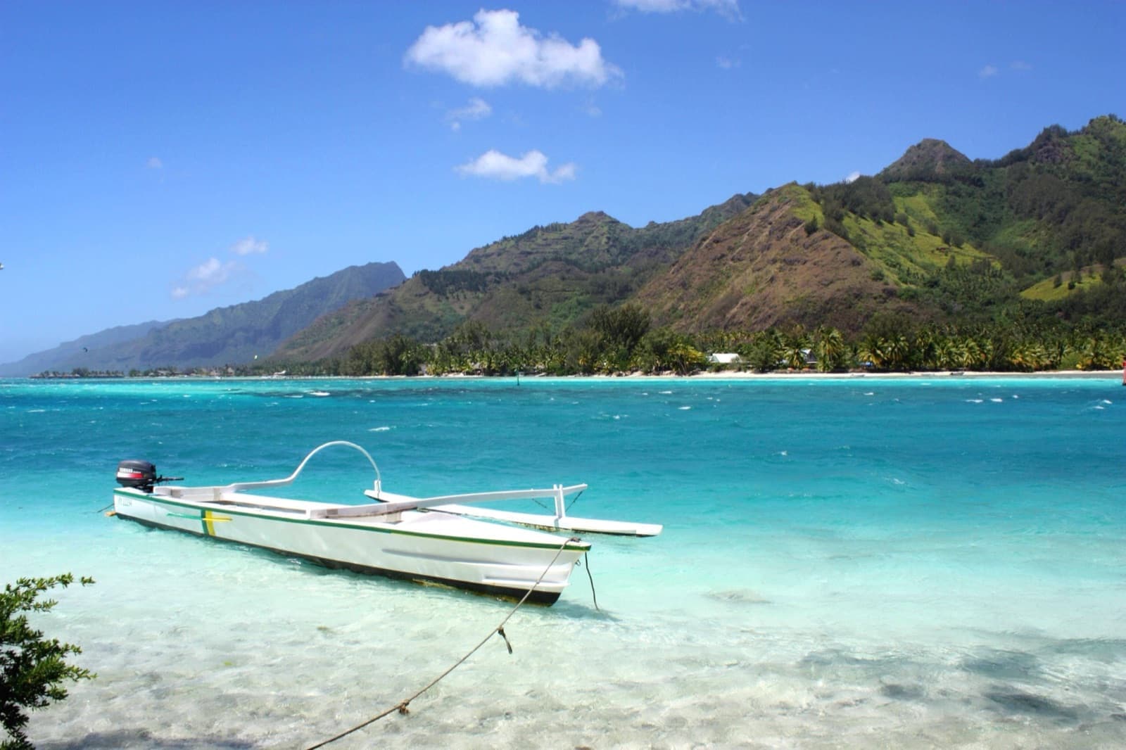 Lagon turquoise et pirogue traditionnelle devant les montagnes de Moorea, en Polynésie française