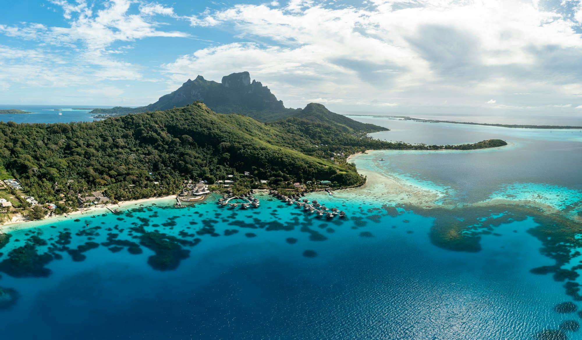 Le lagon de Bora Bora, ses bungalows sur pilotis et le mont Otemanu, en Polynésie française
