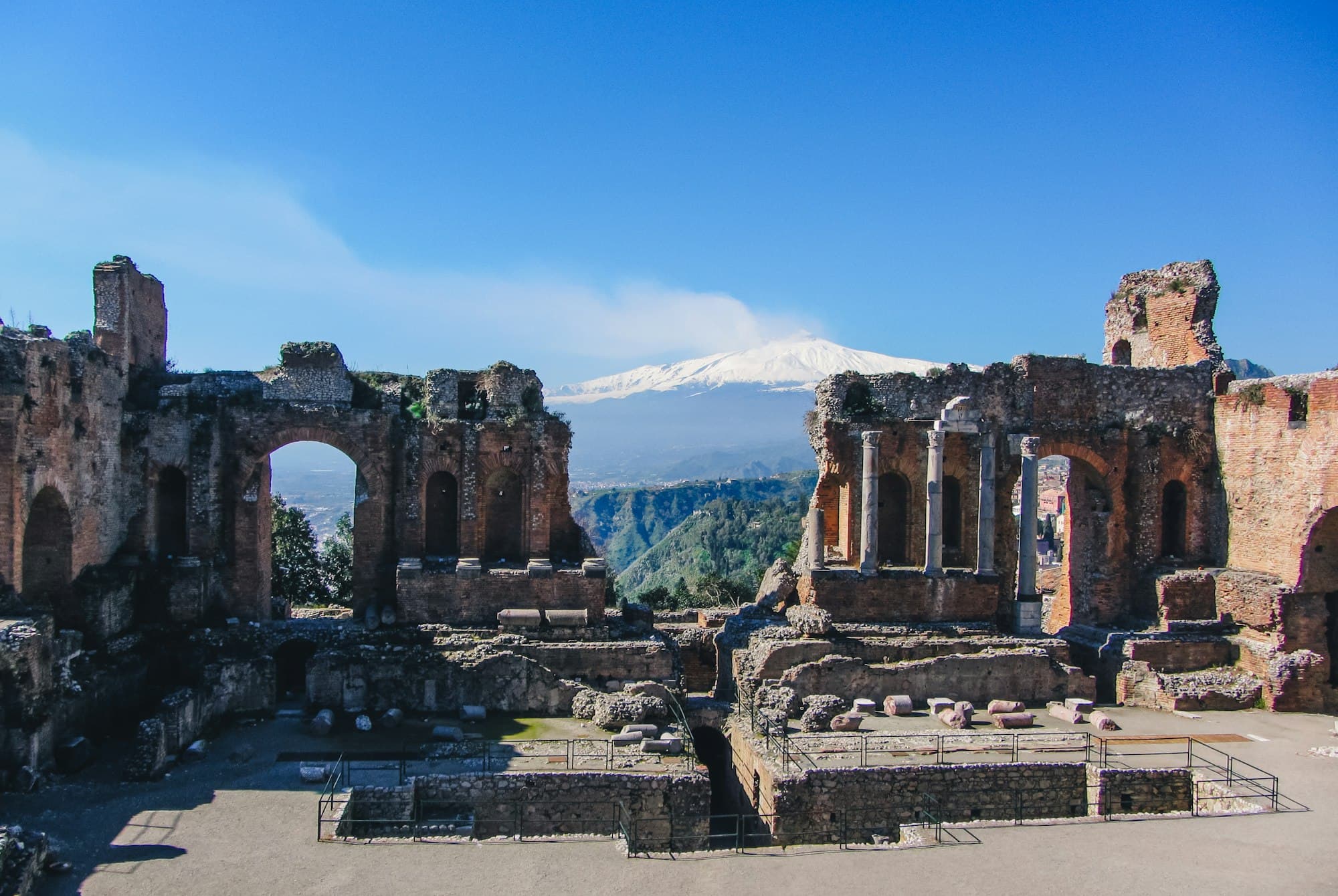Le théâtre antique de Taormine avec l'Etna enneigé en arrière-plan, en Sicile
